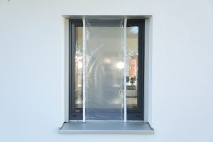 Ein kleines Fenster ist zu einen Drittel mit Malerfolie abgeklebt