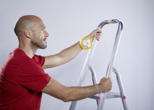 Ein Maler mit der ProTaper Edition von Klauss-Klebeband hantiert mit einer Leiter